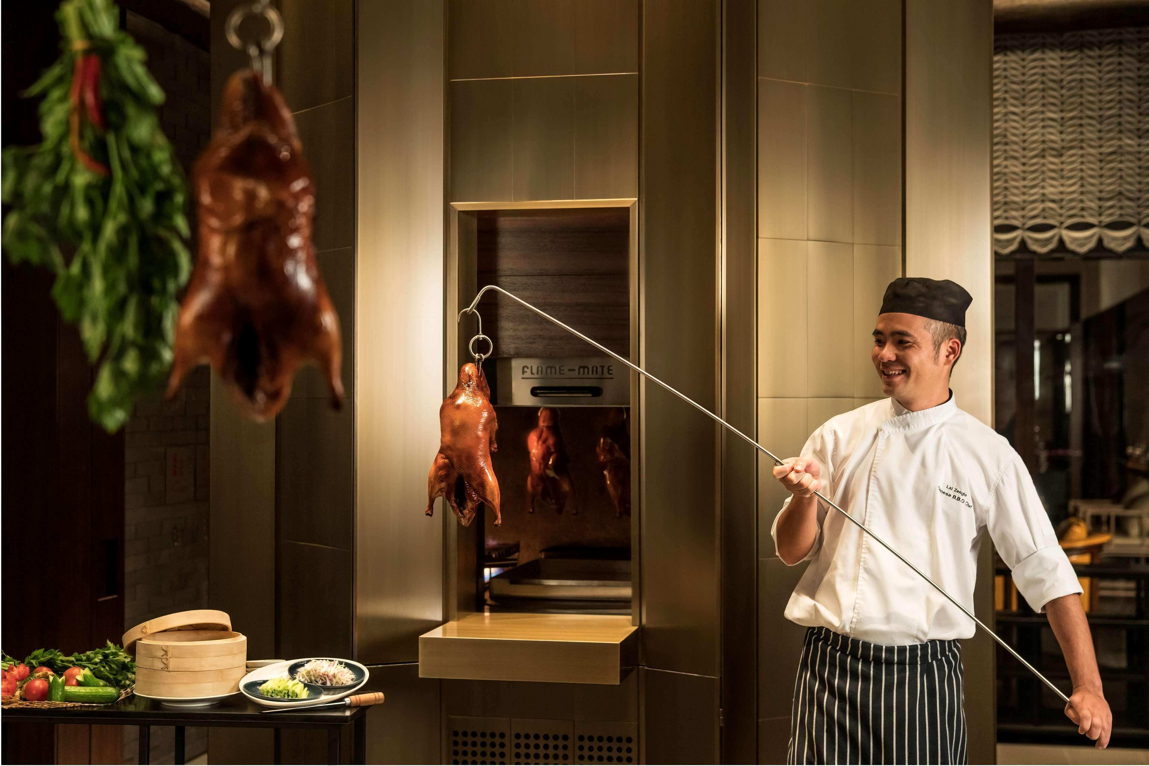 Shangri-La كولمبو المظهر الخارجي الصورة Chef pulling a duck out of a hanging oven